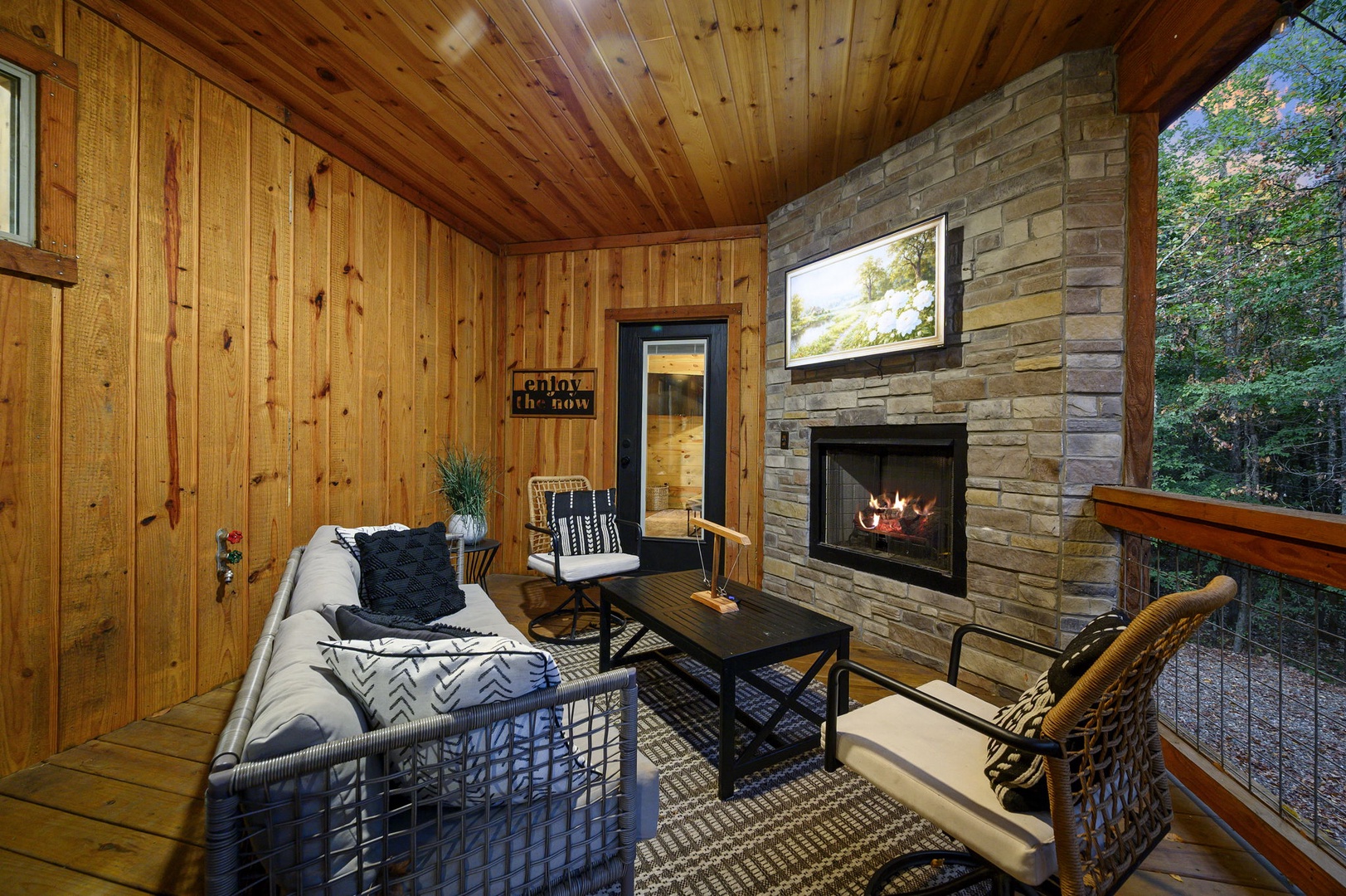 Curl up on this covered porch with a crackling fire and surrounded by peaceful forest views—your perfect spot to unwind with a book or morning coffee.