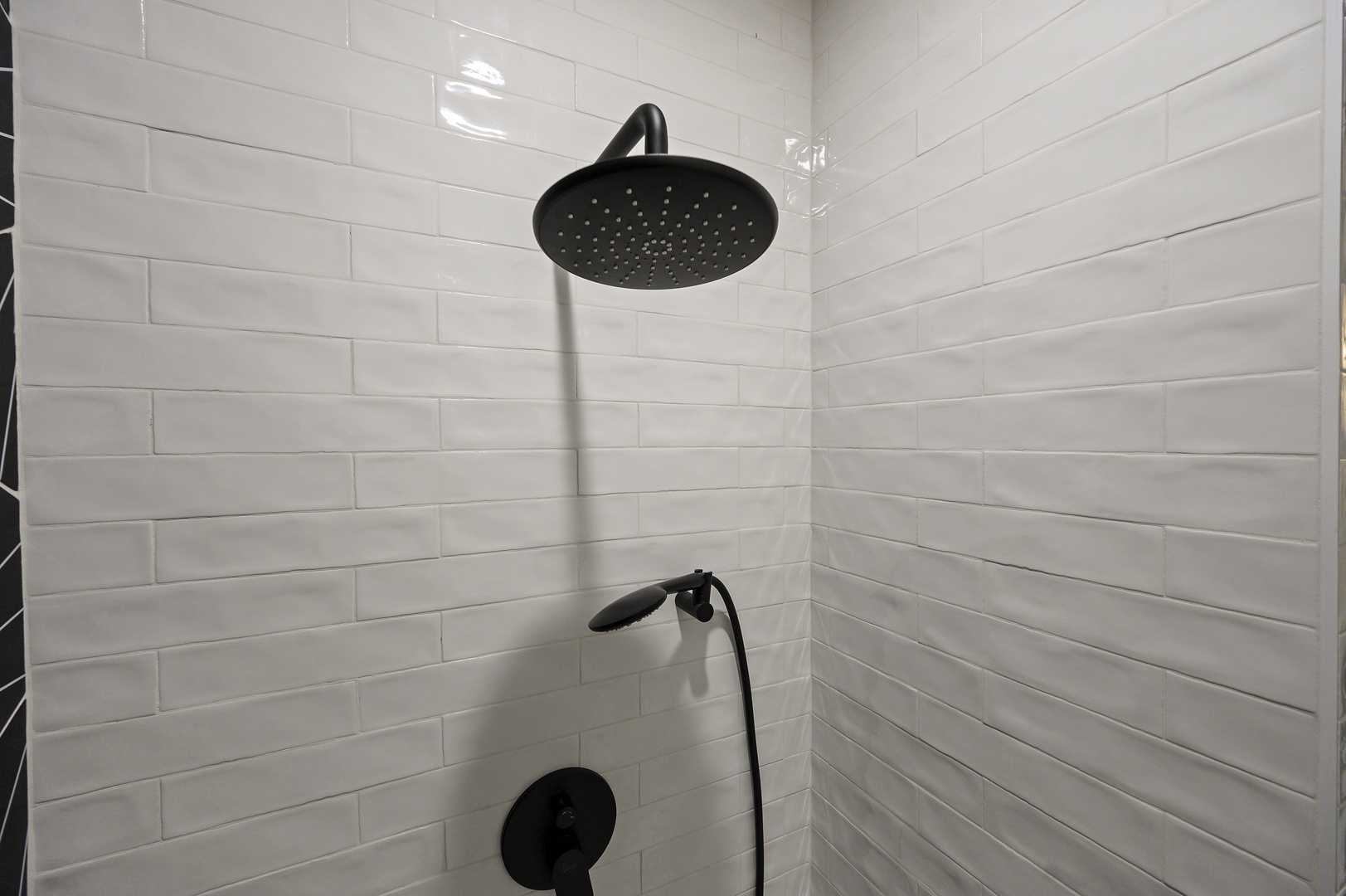 Step into your pristine walk-in shower featuring sleek subway tile and modern black fixtures for refreshing mornings.