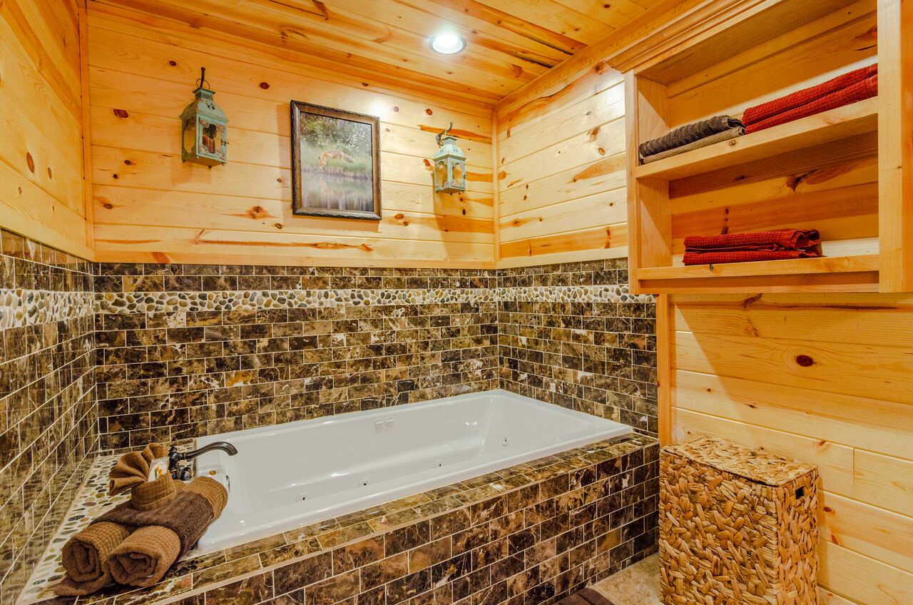 Sink into this stunning jetted tub surrounded by gorgeous stone tile and warm wood. Your plush towels are ready, and everything's been thoughtfully arranged for your perfect soak.