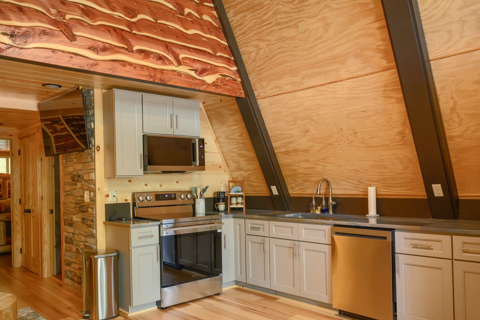 Your A-frame retreat features a full kitchen with modern appliances and warm wood accents, blending rustic charm with all the comforts you need for your stay.