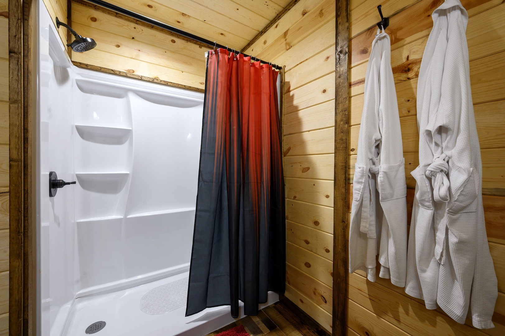 Cozy shower with warm wooden walls and rustic charm.