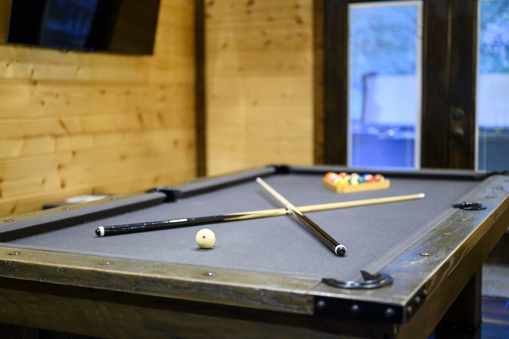 Challenge your friends to a game on this full-size pool table surrounded by warm wood paneling. Natural light from oversized windows brightens every shot, making game night effortless and fun.