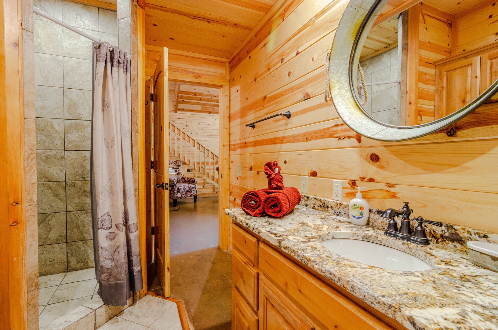 Your private bathroom blends rustic charm with modern comfort—enjoy the spacious shower, warm wood accents, and thoughtful touches like plush towels waiting for you.