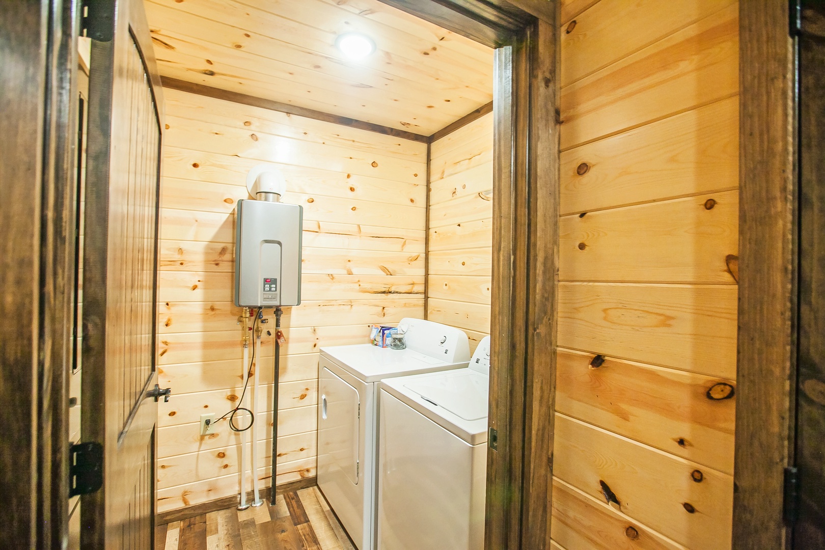 Your rustic laundry room features warm wood walls and modern appliances for convenient clothes care during your stay.