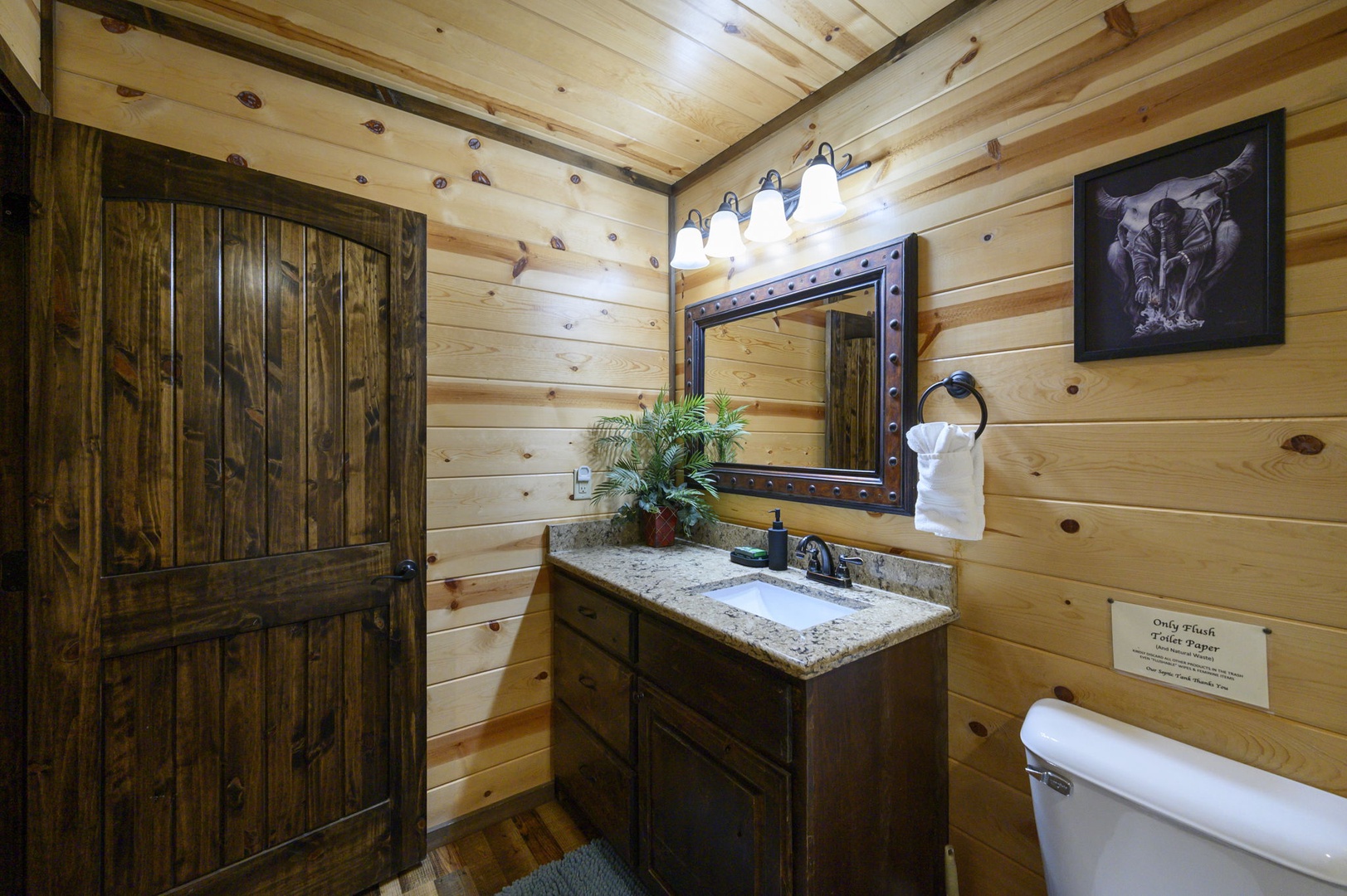 Step into your private cabin bathroom, where rustic wood walls meet modern comforts. Warm lighting illuminates the granite vanity, while thoughtful touches like fresh towels await your arrival.
