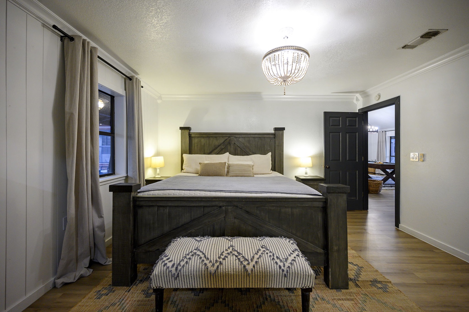 Sink into your rustic-chic retreat with its stunning chandelier casting warm light over crisp linens and rich wood furnishings.