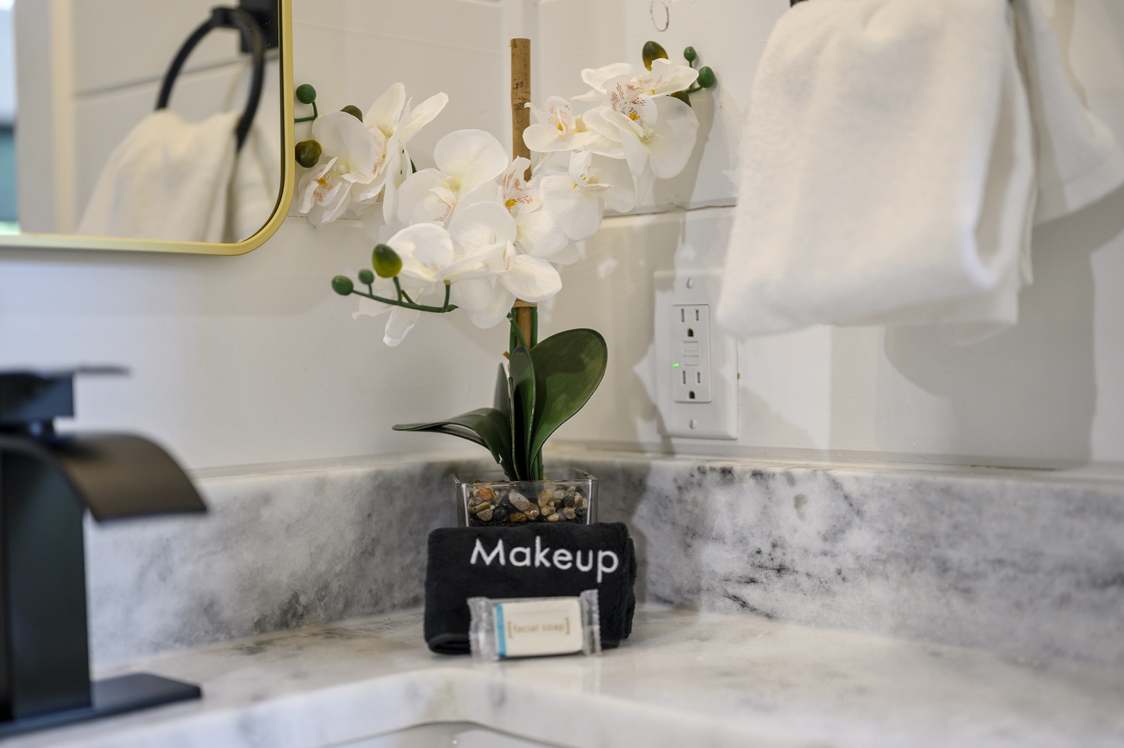 Fresh white orchids and thoughtful touches create your perfect morning routine in this elegant marble bathroom vanity.