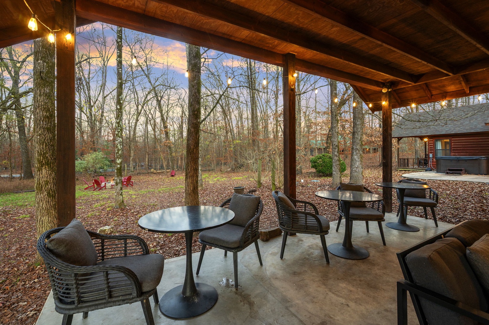 Sip your morning coffee on this tranquil covered patio, where warm string lights and forest views create your perfect woodland retreat.
