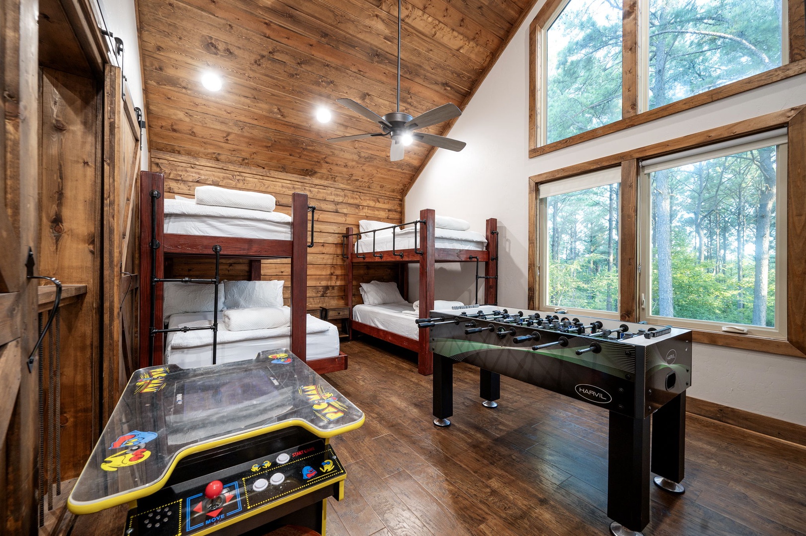 Your group will love this fun-filled bunk room with rustic wood beams, vaulted ceiling, and large windows offering peaceful forest views while you challenge each other to foosball and arcade games.