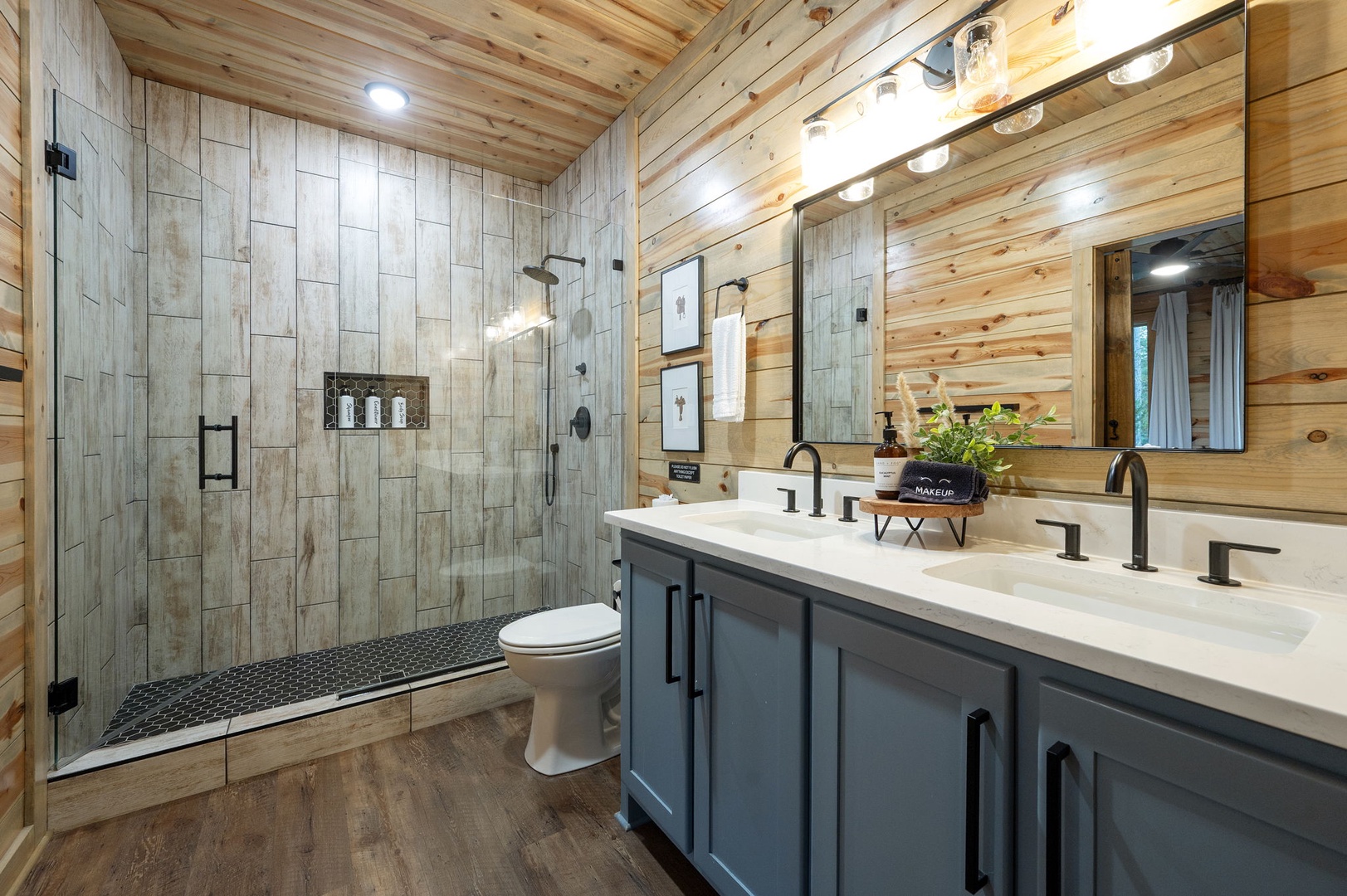 Unwind in your private spa-like bathroom, complete with a spacious walk-in shower, dual vanity sinks, and warm wood-paneled walls that wrap you in cozy mountain charm.