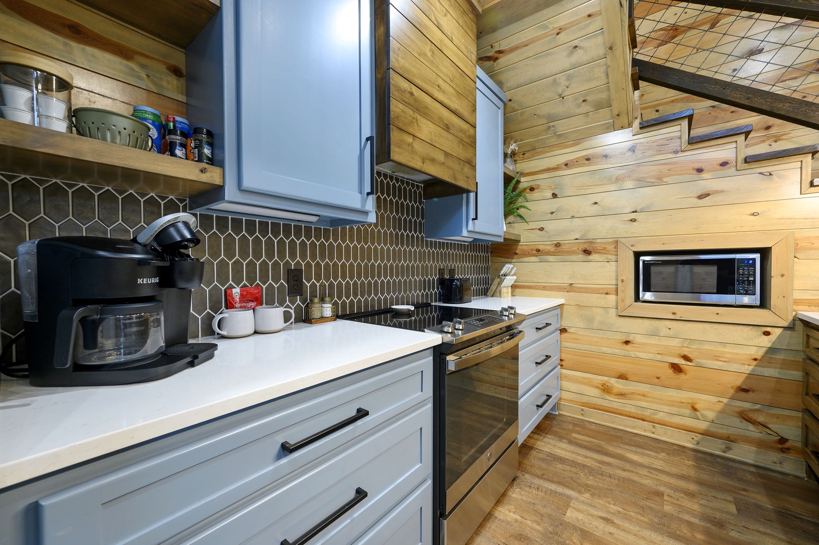 Your cozy retreat comes with a fully equipped kitchen featuring modern appliances and charming wood-paneled walls. Everything you need to prepare meals in comfort, from the stove and microwave to fresh coffee each morning.