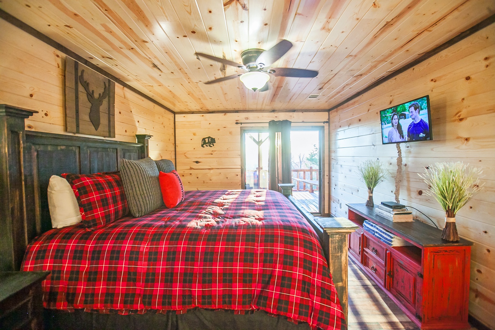 Snuggle into your cozy cabin bedroom with rustic charm, plaid bedding, and mountain views through sliding doors.