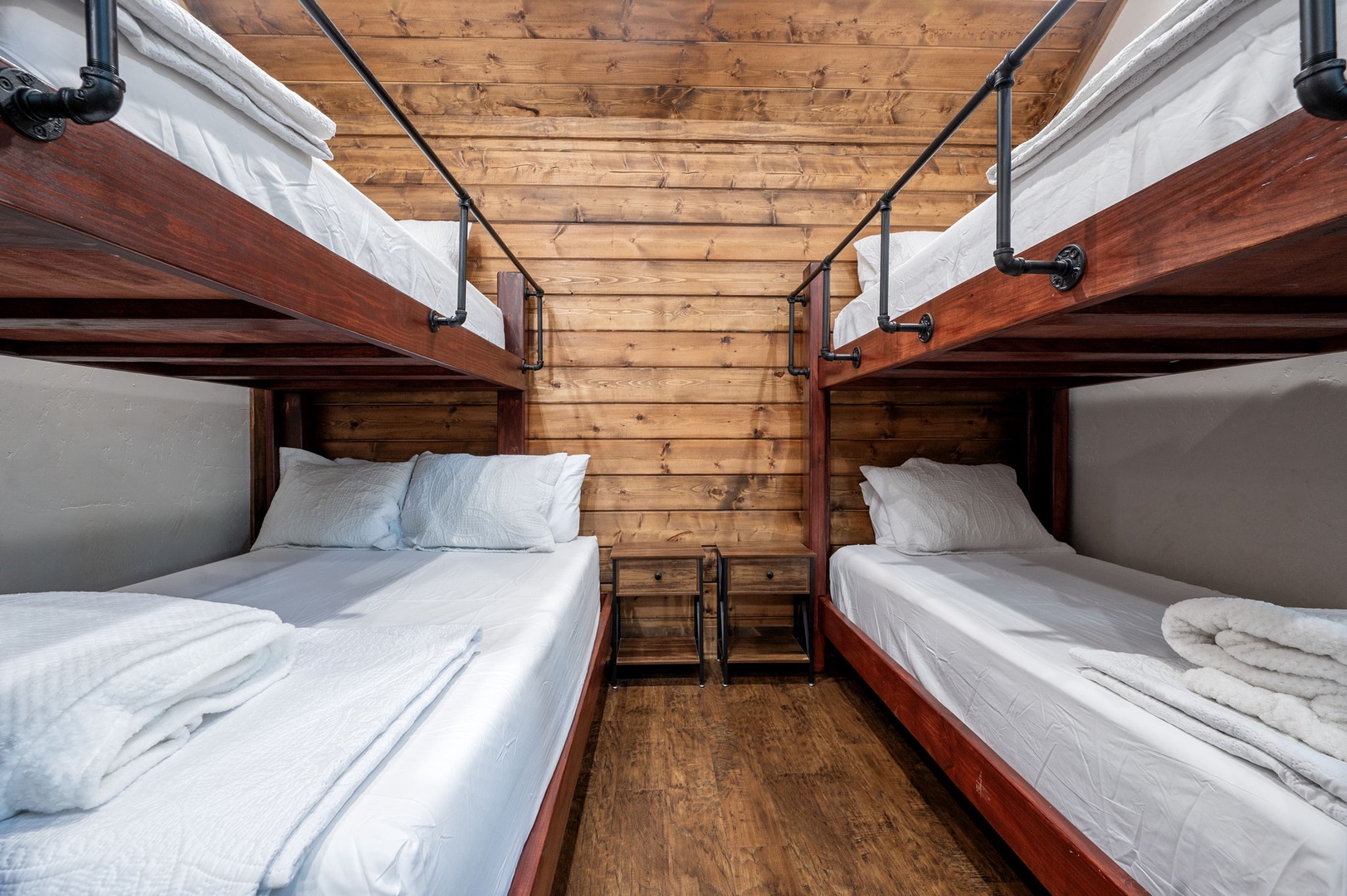 Rustic charm meets cozy comfort with four plush bunk beds and warm wood-paneled walls, perfect for your group or family getaway.