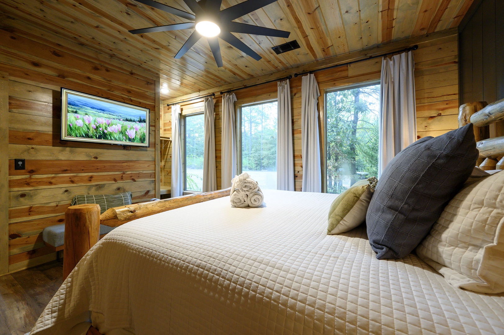 Sink into the plush comfort of your rustic-chic bedroom, where warm pine walls and a handcrafted log bed frame create a cozy retreat after a day of adventure.