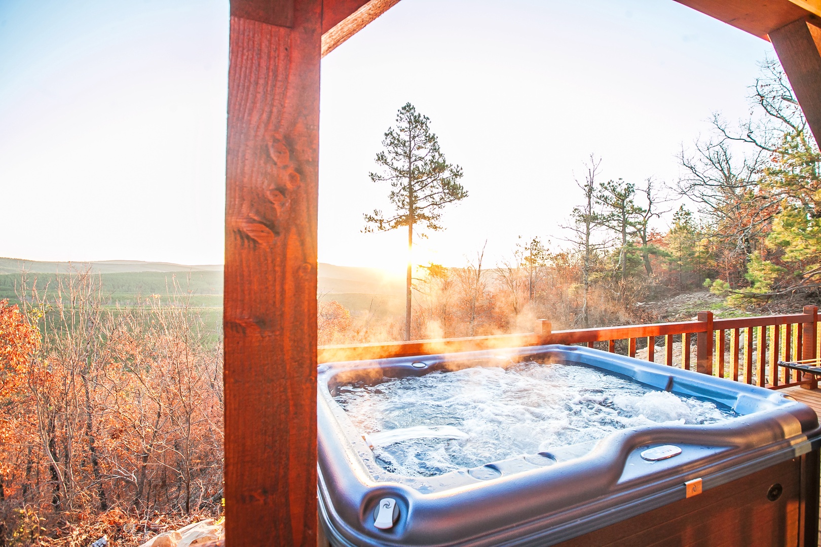 Unwind in your private hot tub as golden sunlight filters through autumn trees, creating the perfect backdrop for relaxation.
