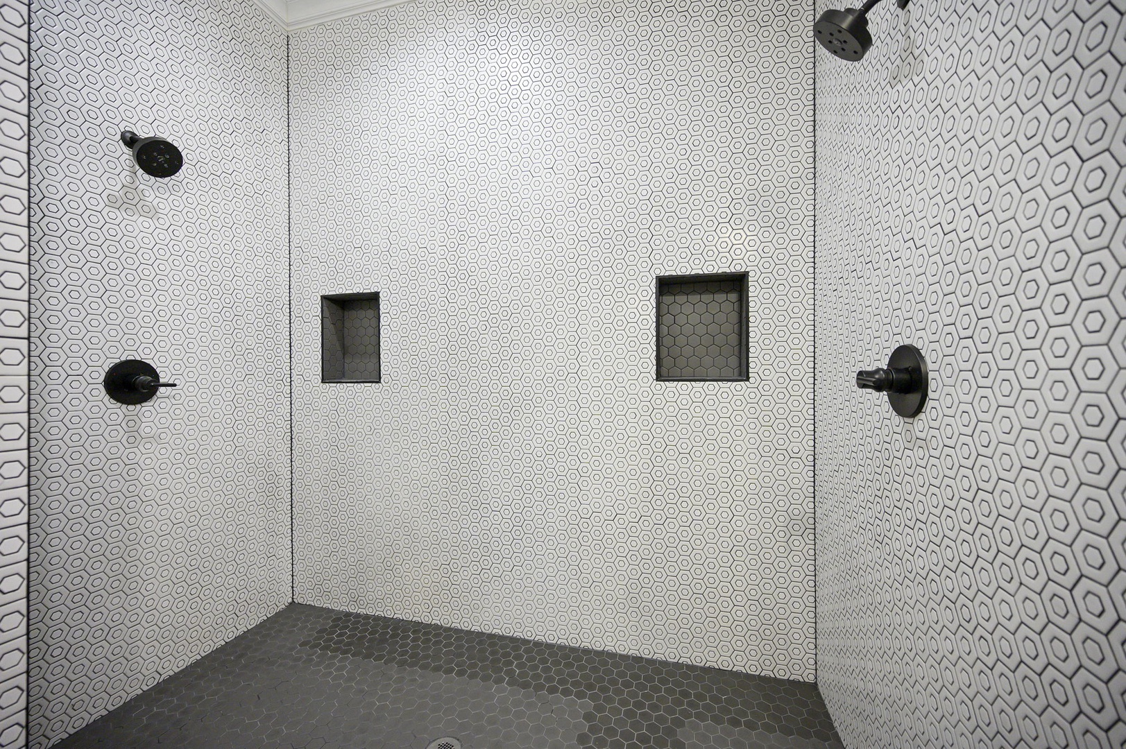 Step into your luxurious spa-like shower with stunning geometric tiles, dual rainfall heads, and built-in niches for your essentials.