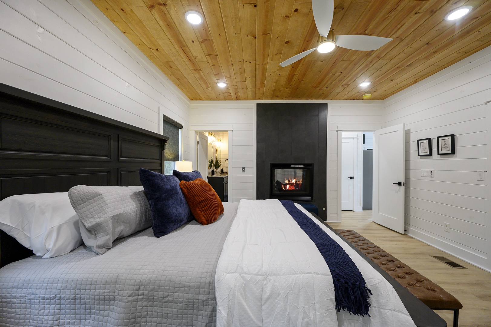 Drift off in your cozy bedroom featuring stunning wood ceilings, a warming fireplace, and crisp linens that invite peaceful rest.
