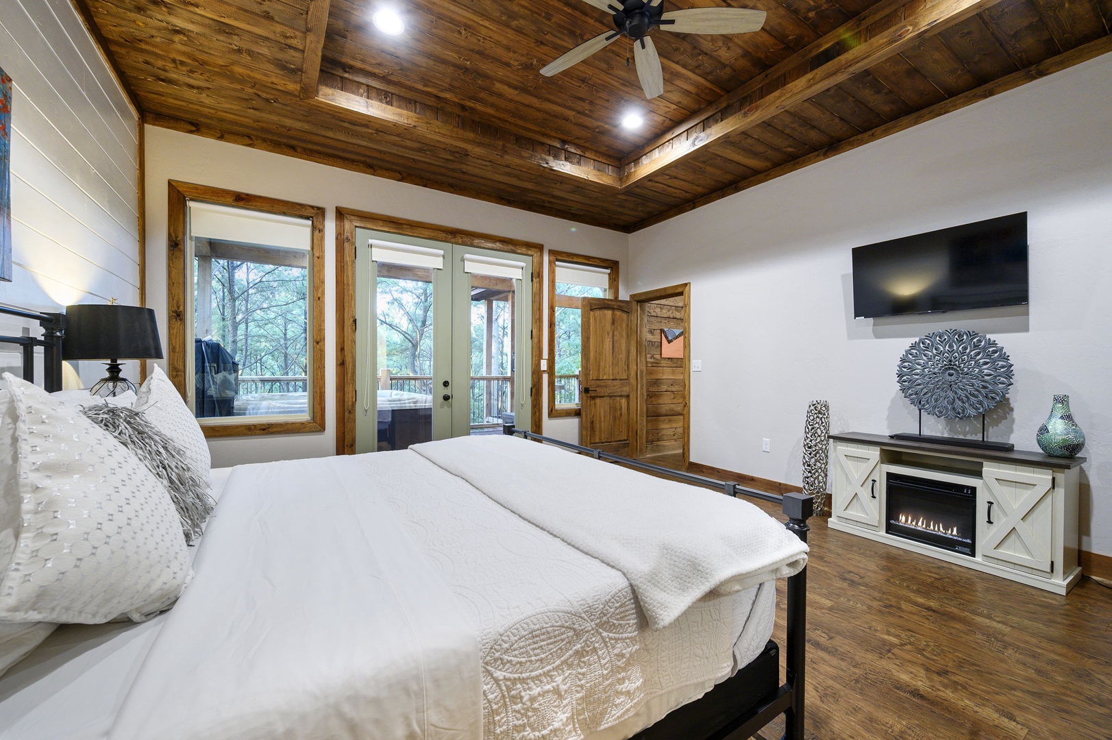 Drift off under rustic wood beams with views of nature through your windows. The cozy fireplace and private balcony access make this retreat perfect for peaceful mornings and starlit evenings.
