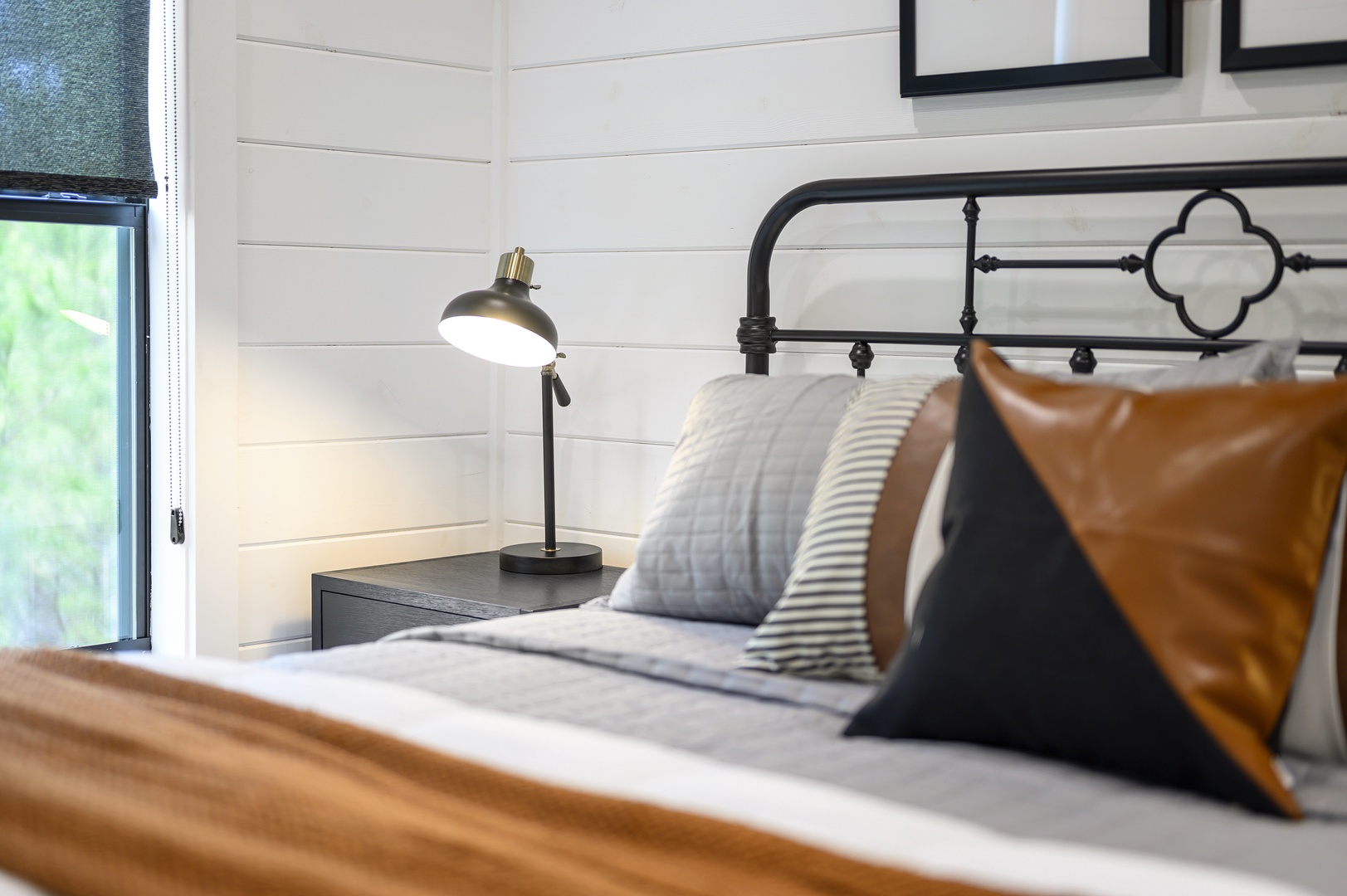 Slip into crisp linens and cozy pillows in your stylish bedroom, where a vintage reading lamp creates the perfect bedtime ambiance.
