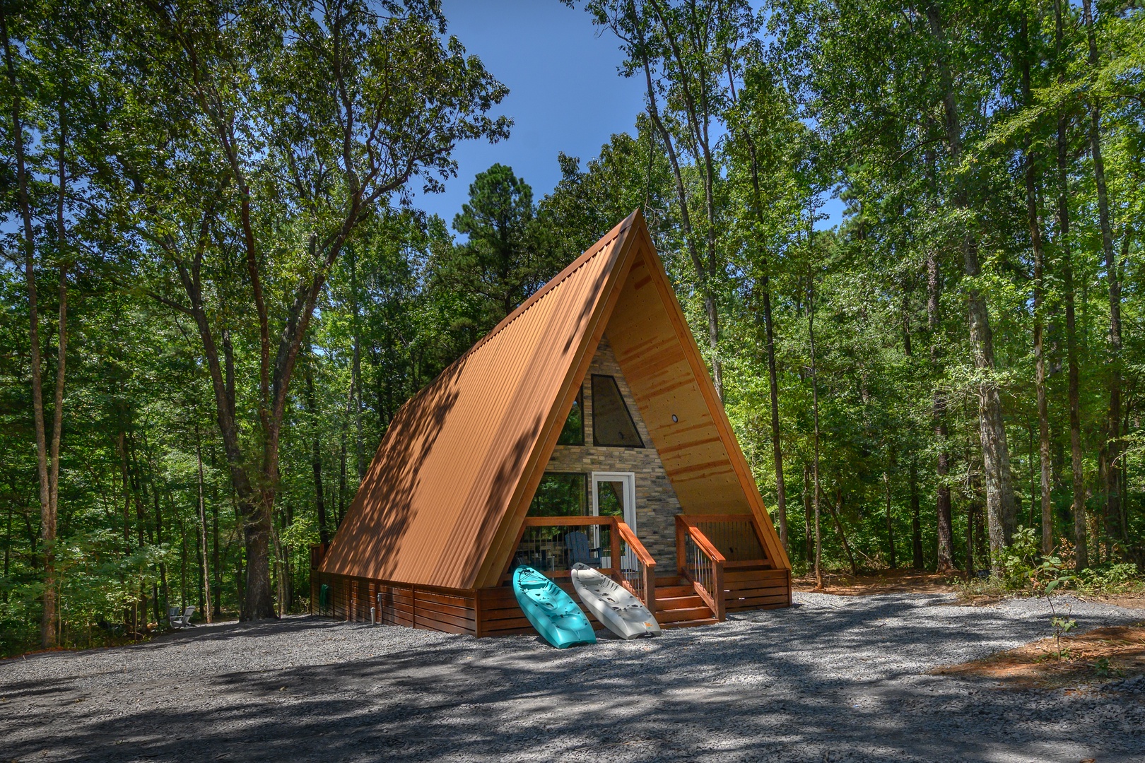 A charming A-frame cabin nestled in a peaceful forest setting, surrounded by towering hardwoods and natural tranquility.