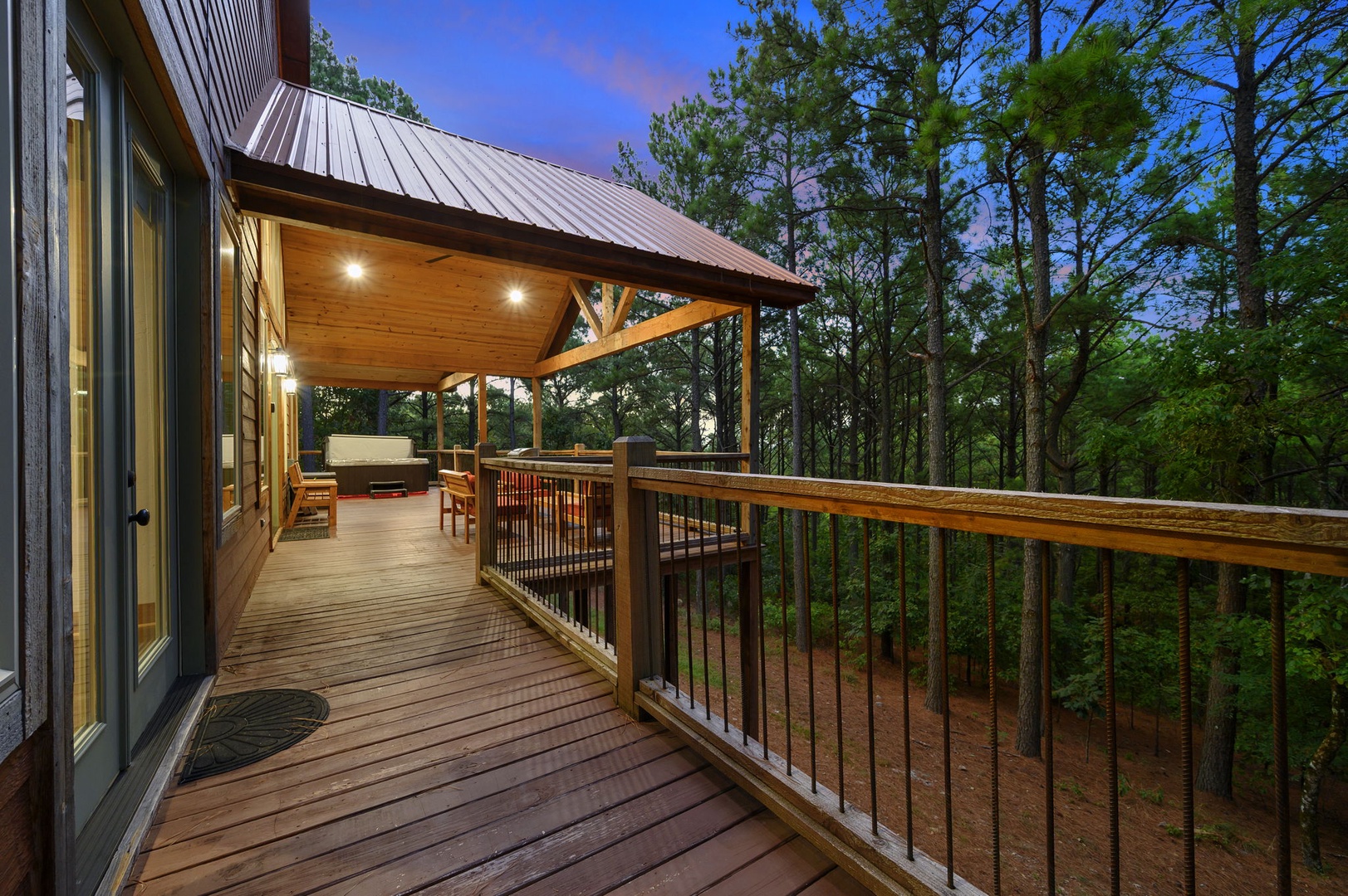 Retreat to your private covered deck at dusk, where the forest whispers just beyond your railing and outdoor seating awaits your evening relaxation.