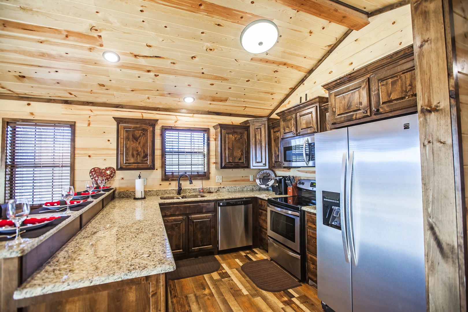 Your rustic cabin kitchen awaits with granite counters, stainless appliances, and warm wood beams overhead—perfect for cooking memorable mountain meals.
