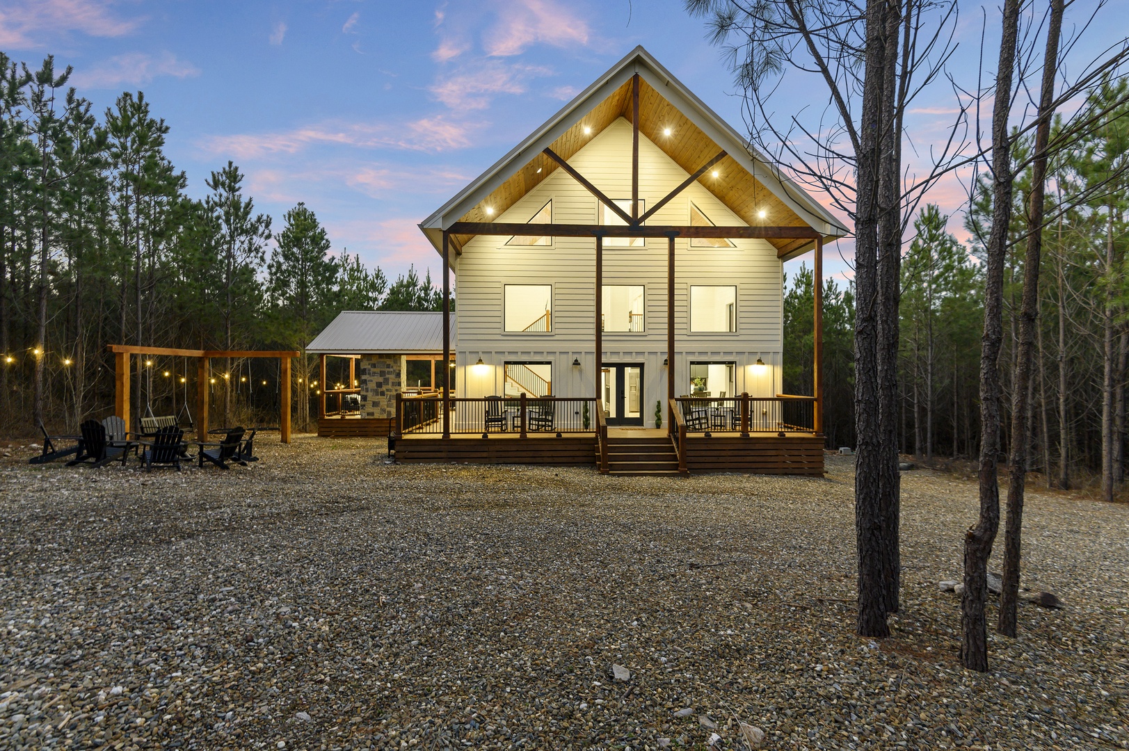 Modern cabin nestled among towering pines with expansive decks and outdoor seating areas for peaceful forest evenings.
