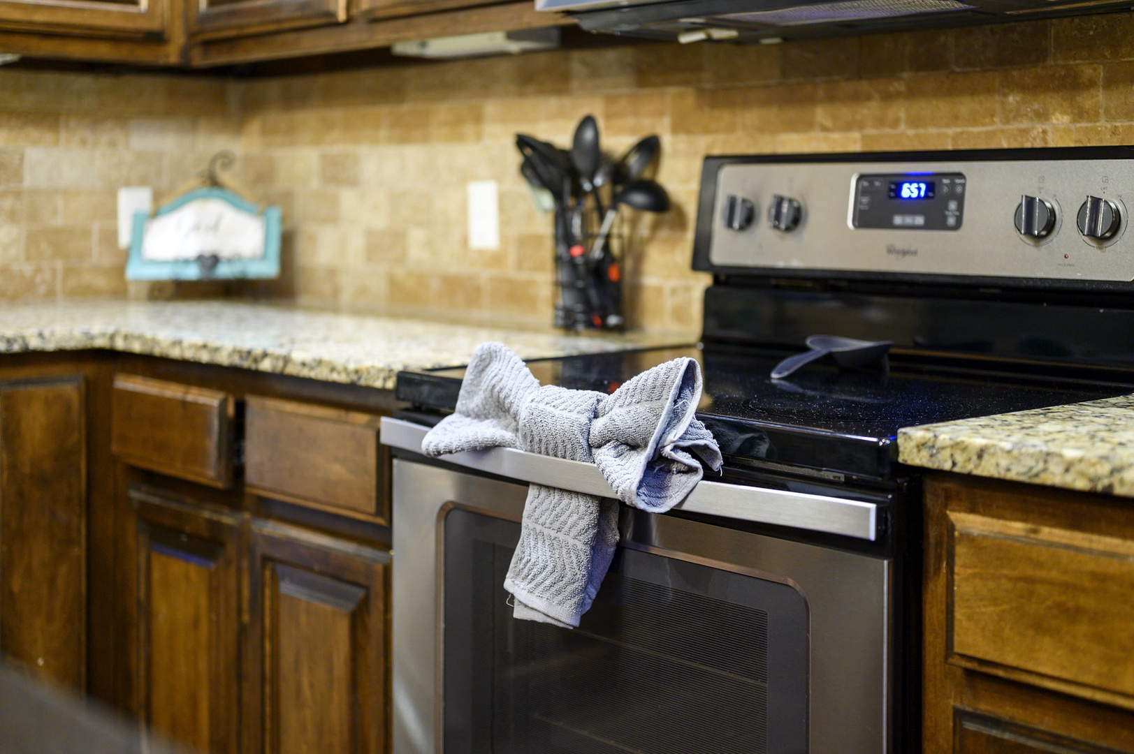 Your fully equipped kitchen awaits with gleaming granite counters, a modern stove ready for your culinary creations, and warm wood cabinetry that makes meal prep feel effortless.