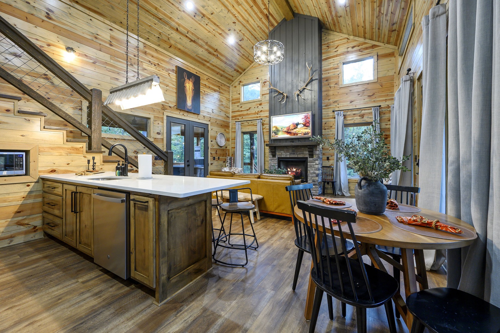 Step inside your cozy mountain retreat, where soaring wood ceilings, a crackling stone fireplace, and modern kitchen await. Imagine preparing meals at the spacious island, then gathering around the dining table for unforgettable evenings.