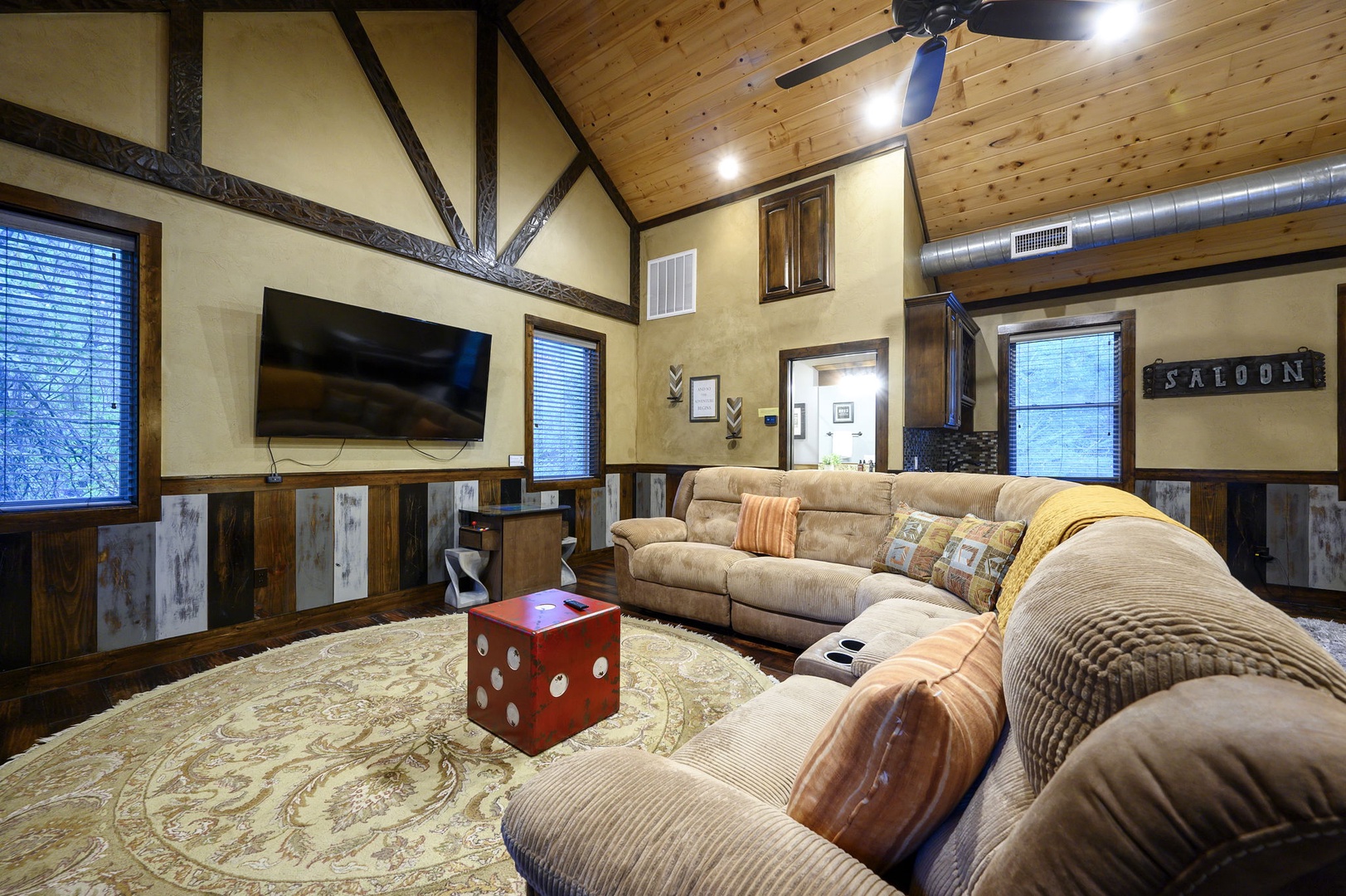 Sink into plush sectional seating and enjoy movie nights in this inviting living room, where vaulted wood ceilings and rustic charm create a warm, spacious retreat for you and your group.