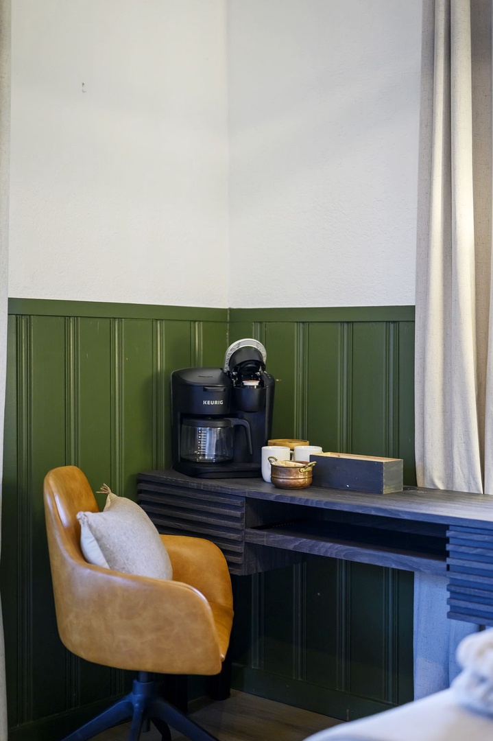 Your morning ritual begins at this stylish coffee station, where rich green wainscoting frames your personal brewing setup.