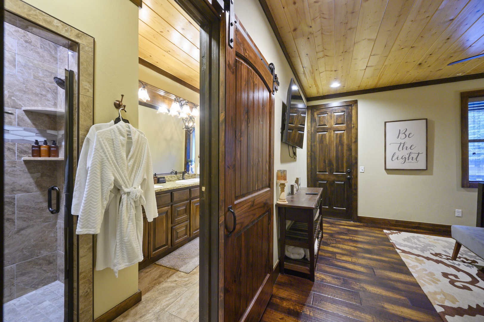 Step through rustic barn doors to discover your private retreat—a luxurious ensuite with spa-like shower, warm wood tones, and plush robes waiting just for you.