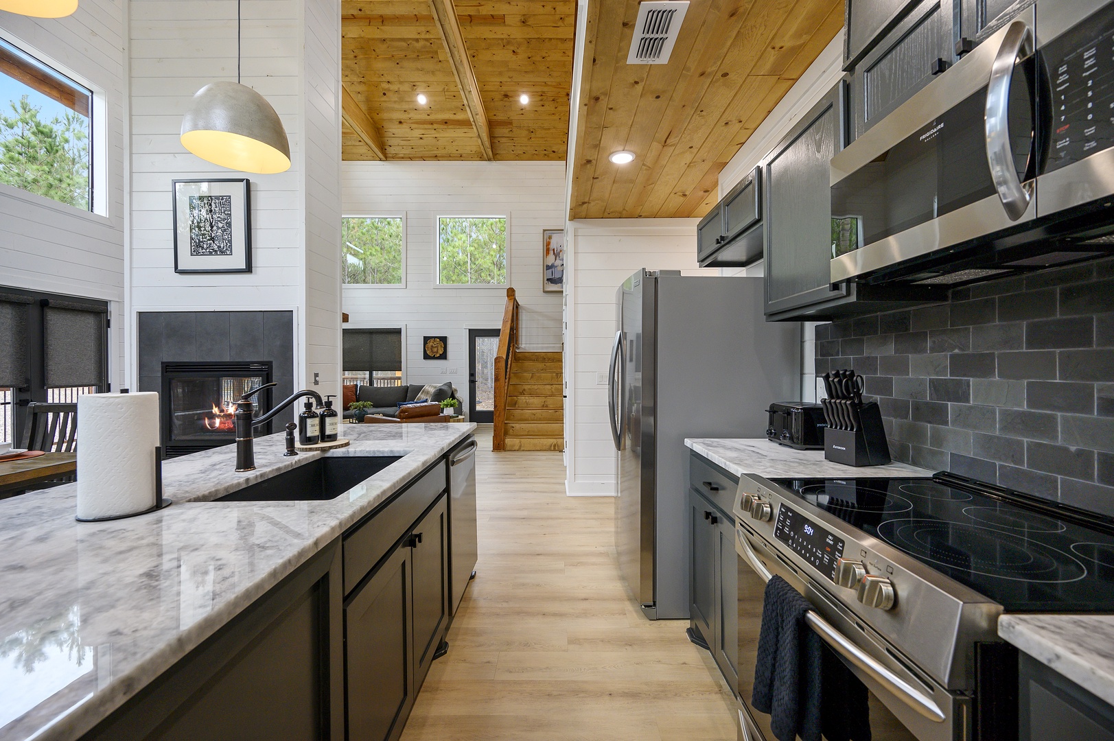 Cook in your sleek modern kitchen with marble counters, stainless appliances, and soaring wood beam ceilings that blend rustic charm with contemporary style.