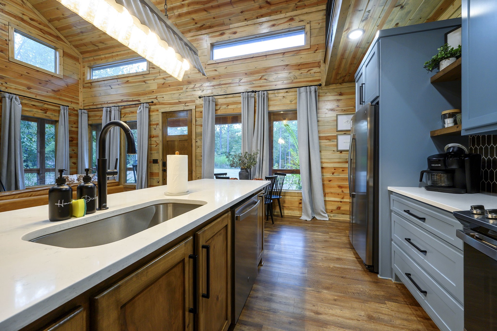 Warm wood and modern touches make this kitchen your perfect retreat. Natural light floods through skylights and windows framing the trees, while sleek appliances and thoughtful design invite you to cook, gather, and unwind in style.
