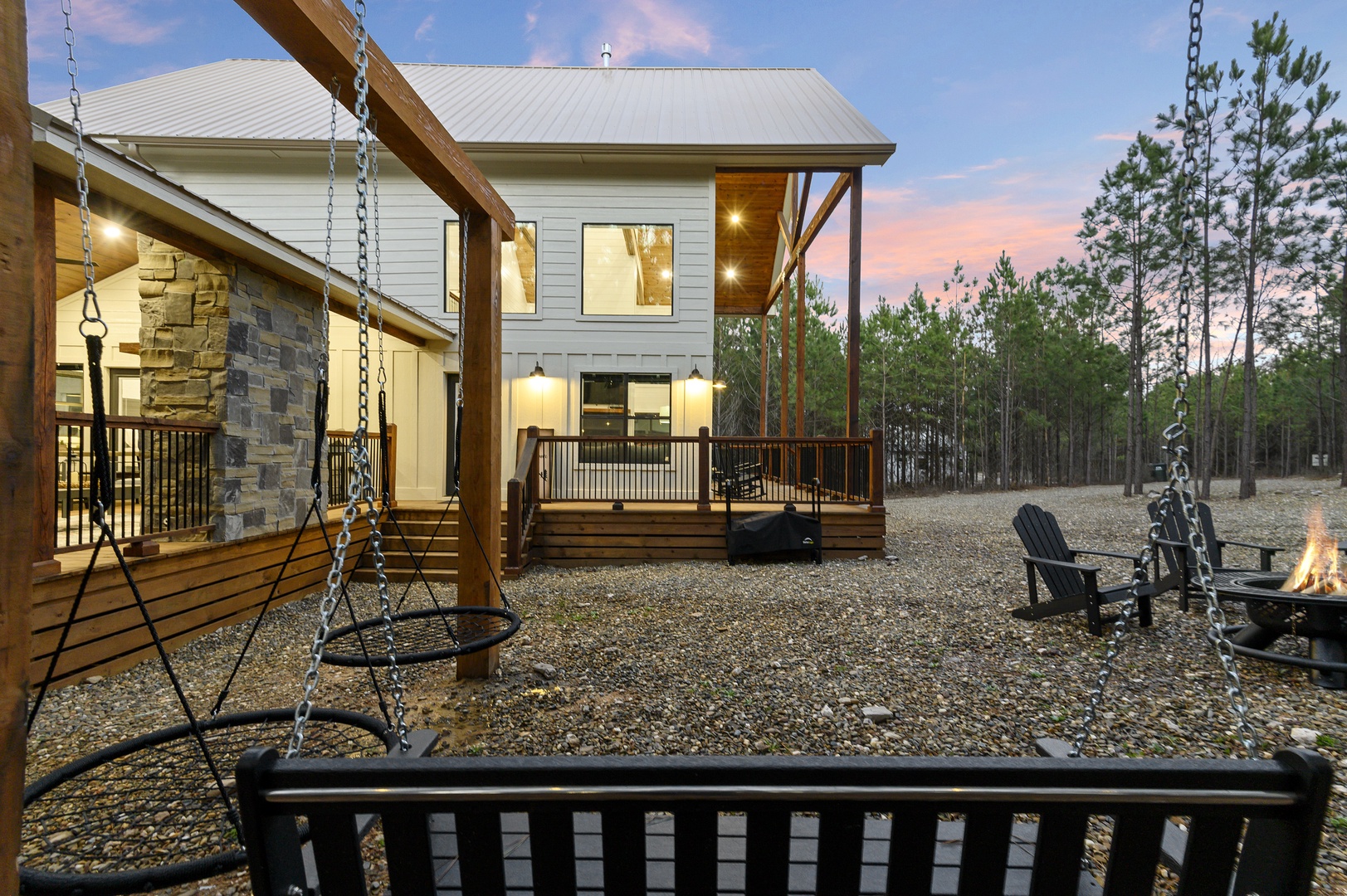 Modern vacation home with spacious deck, outdoor fire pit, and forest setting perfect for peaceful getaways.