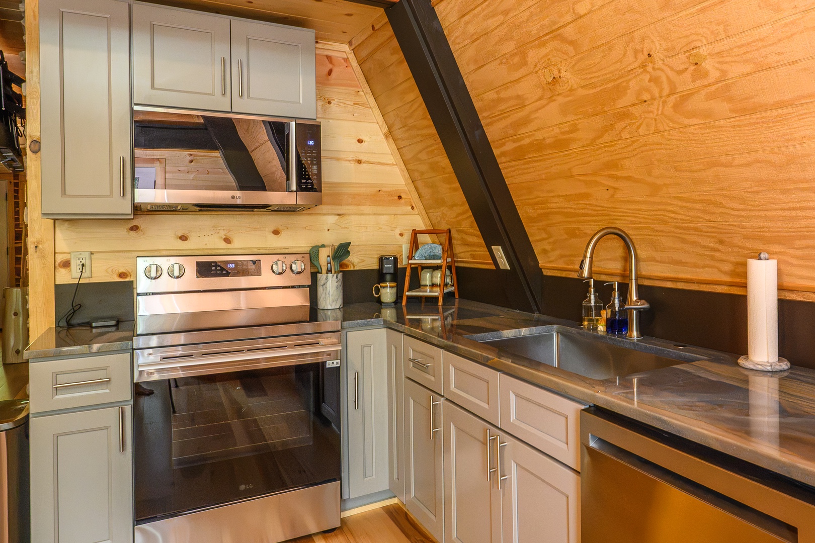 Your fully equipped kitchen features modern appliances and ample counter space beneath warm wood vaulted ceilings, creating an inviting space to prepare meals during your stay.