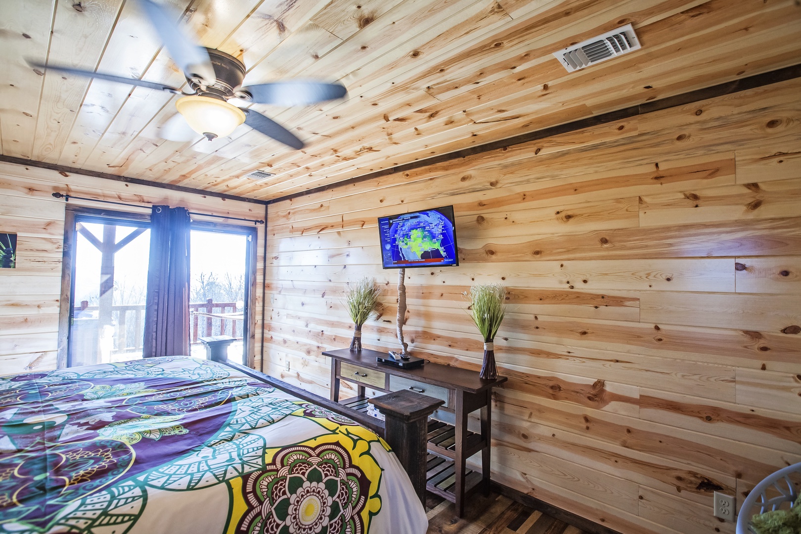 Wake up in your rustic wood-paneled sanctuary with warm natural light streaming through your private balcony door.