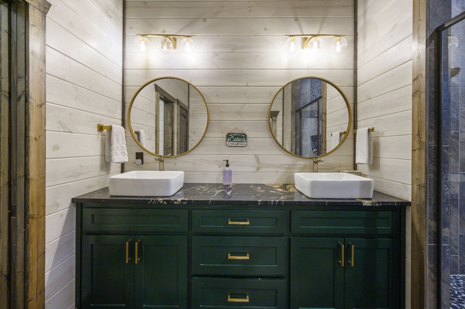 Your elegant double vanity features vessel sinks, round brass mirrors, and modern fixtures against warm shiplap walls—refined comfort for refreshing mornings.