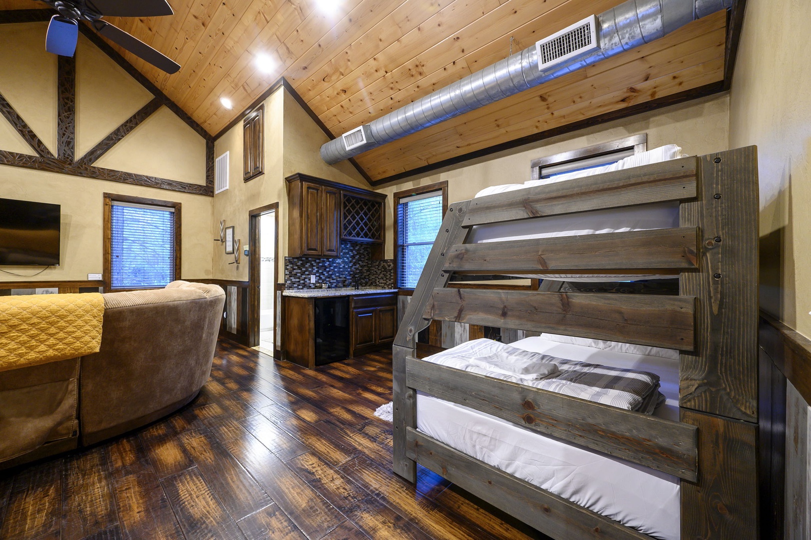Enjoy the cabin's cozy open layout with vaulted wood ceilings, modern kitchen, and rustic bunk beds—perfect for gathering everyone under one roof.