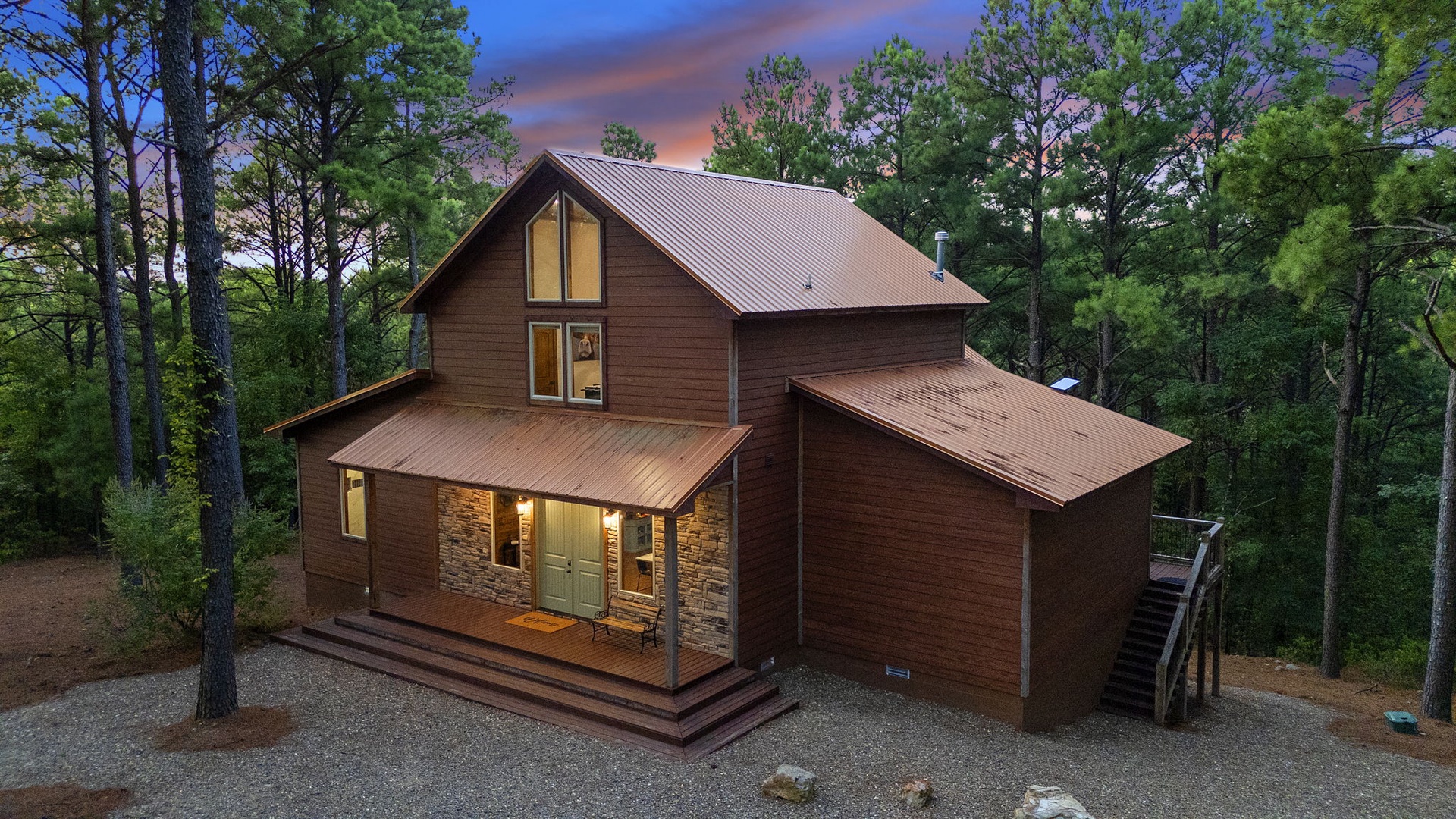 This inviting cabin nestled among towering pines offers a peaceful mountain retreat, with warm lighting welcoming you home after a day of adventure in the surrounding forest.