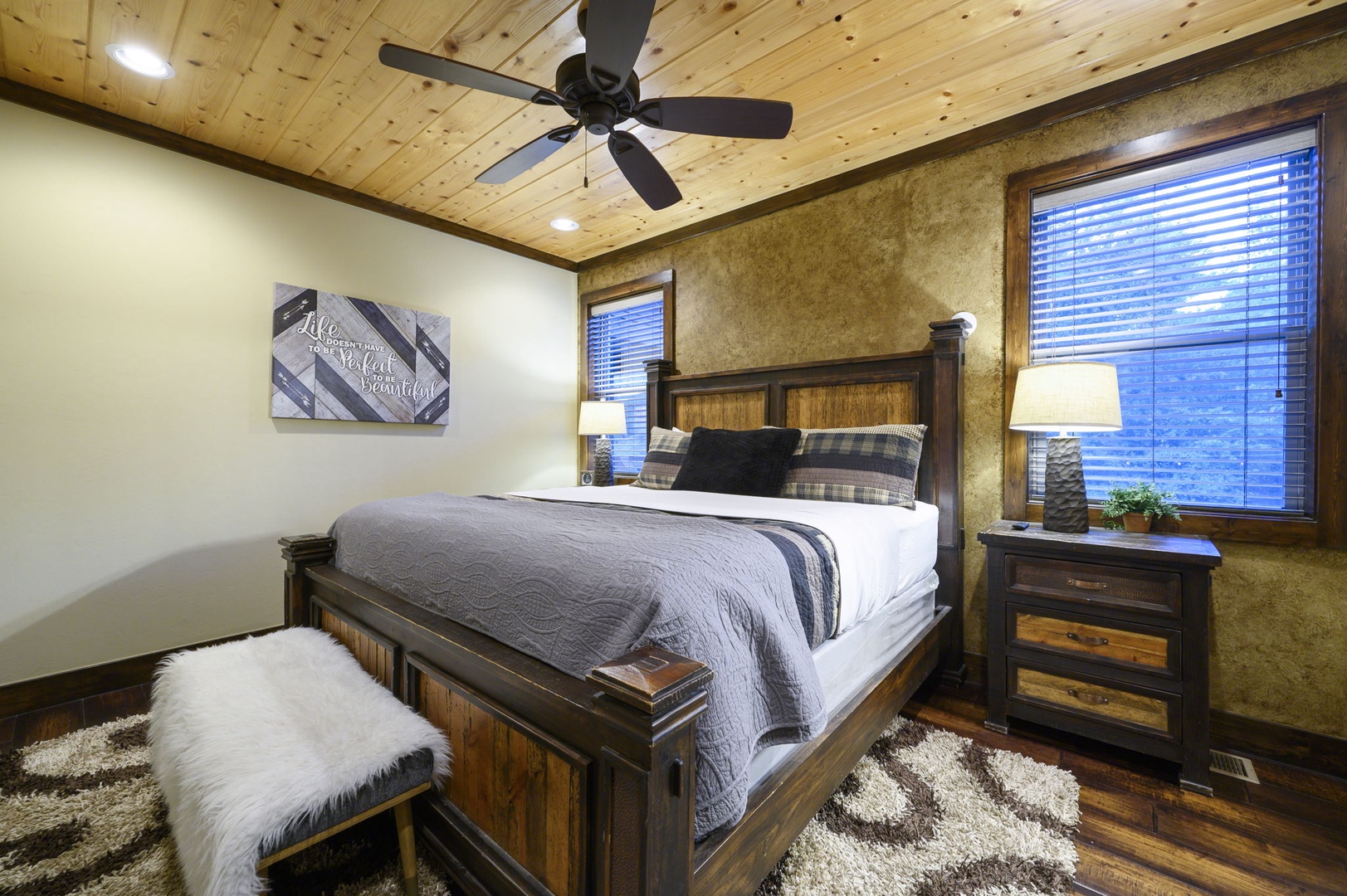 Your cozy retreat with rustic charm, featuring a plush bed under warm wooden beams and a ceiling fan to keep you comfortable year-round.