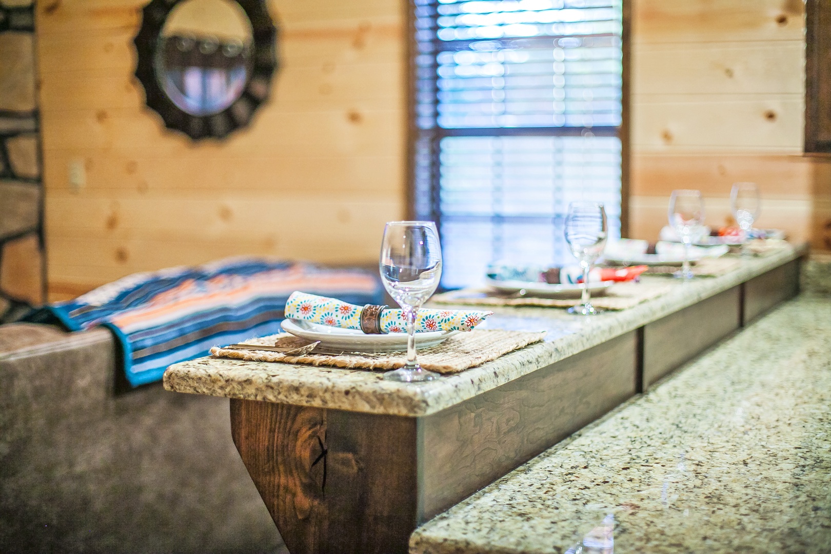 Your rustic dining table awaits with granite surfaces and warm wood accents, perfect for intimate meals by the window.