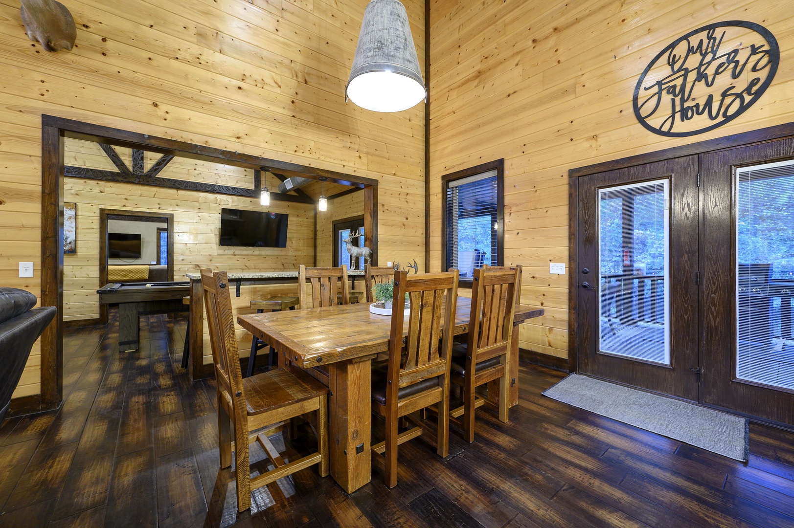 Step into a warm, inviting space where rustic charm meets comfort. The dining table beckons for shared meals and laughter, while the cozy ambiance of natural wood surrounds you—your retreat awaits just beyond those doors.