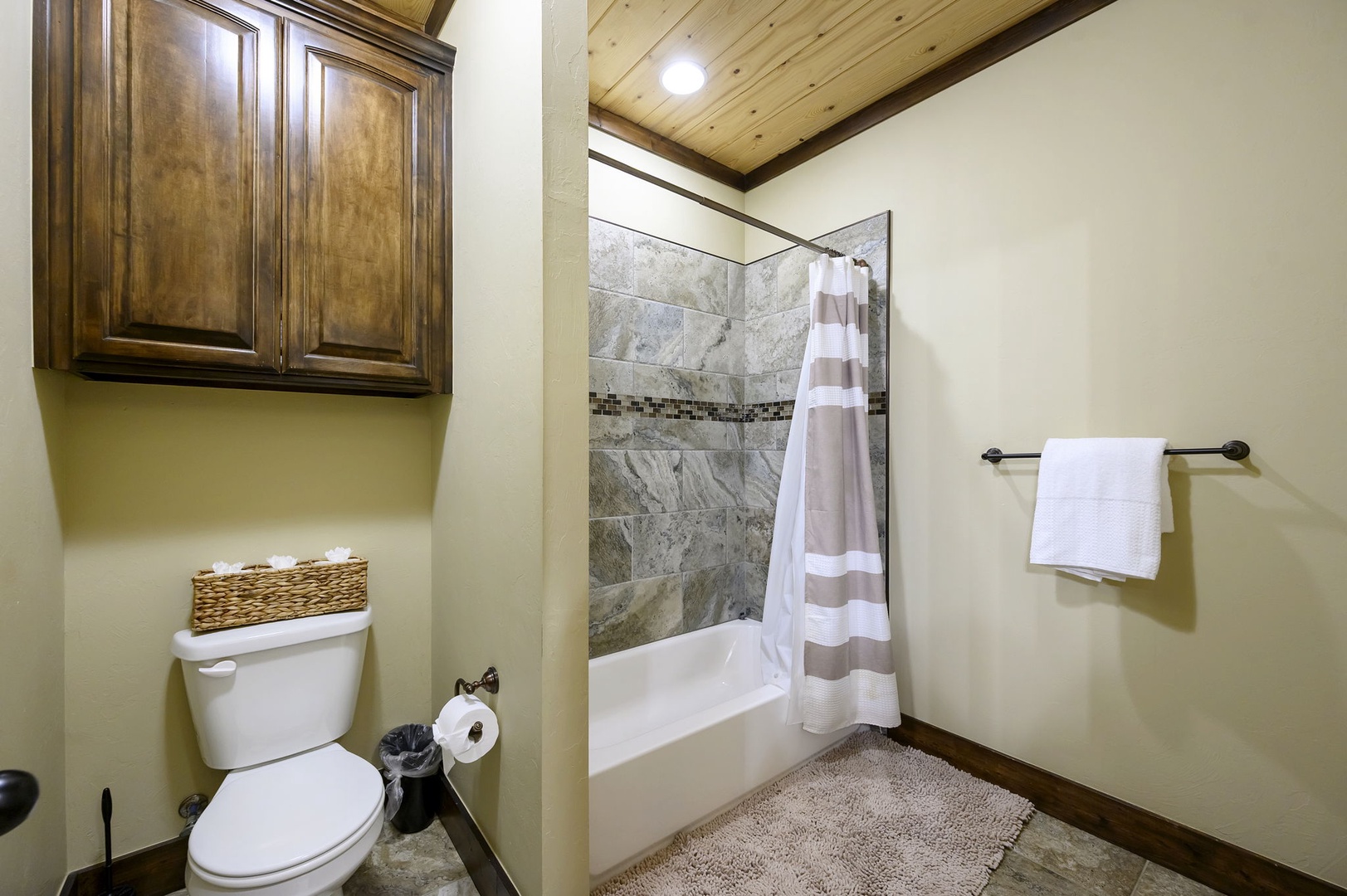 Unwind in your private bathroom with a marble-tiled shower-tub combo and rustic wood accents that bring warmth and character to your mountain retreat.