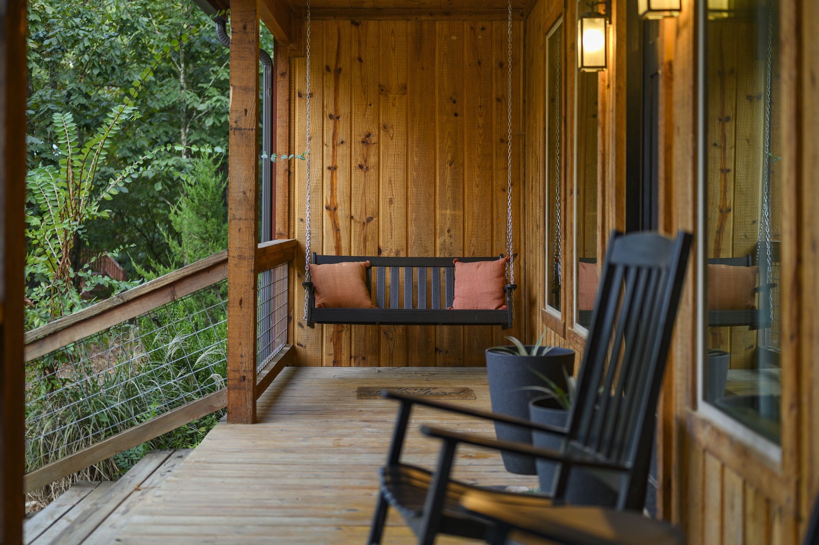 Sway gently on your private porch swing while forest views and soft rocking chairs invite you to unwind completely in this peaceful wooded sanctuary.