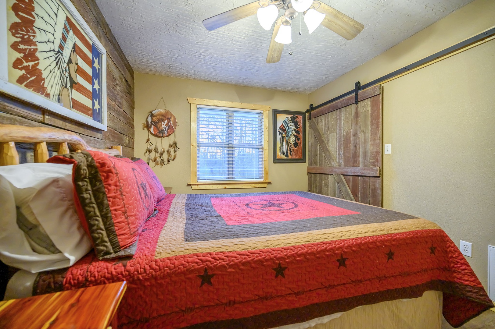 Drift off in this cozy Western-themed bedroom where rustic barn doors and Native American artwork create your perfect retreat.