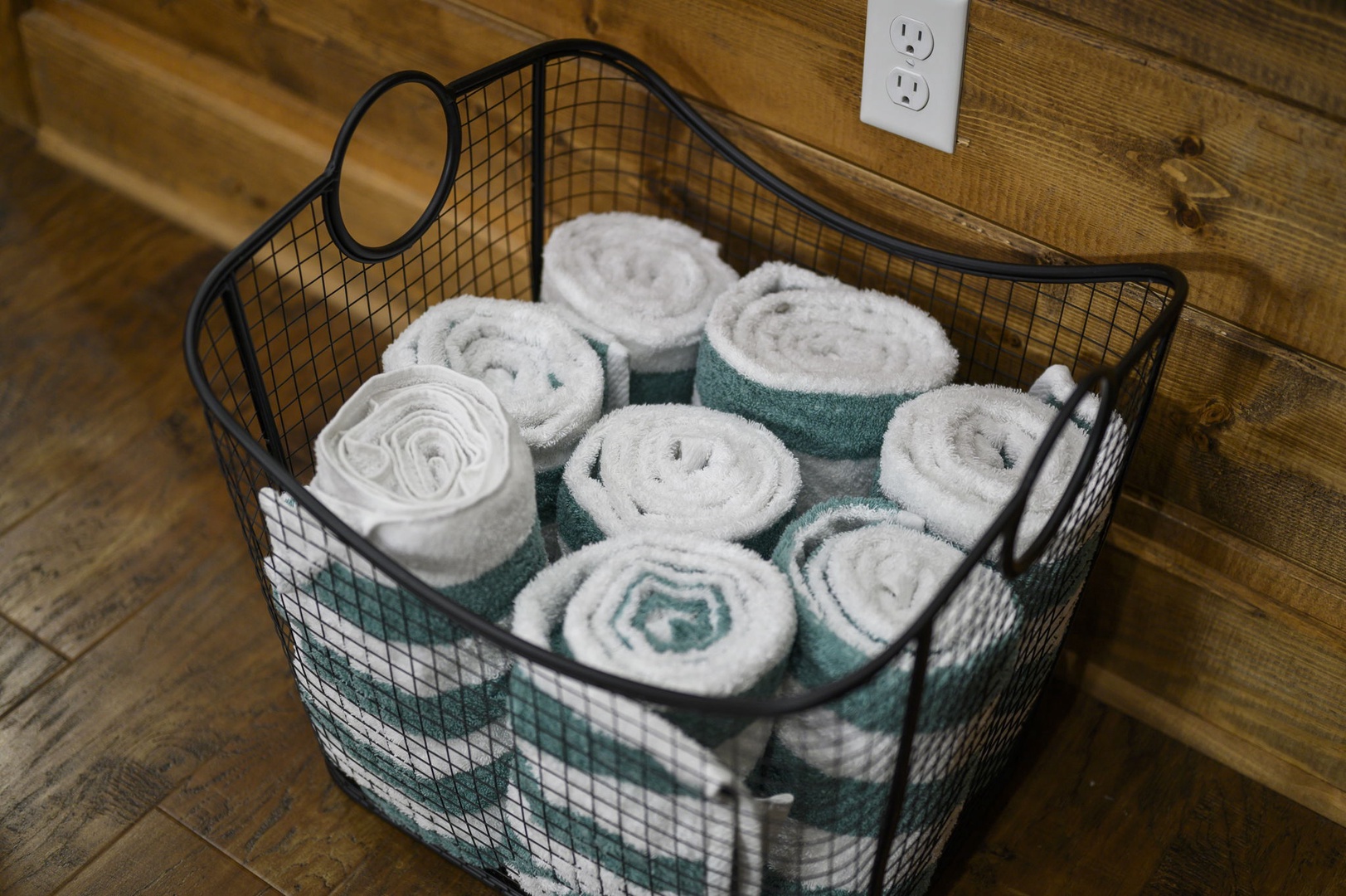 Fresh, fluffy towels await you in a charming wire basket, perfectly rolled and ready for your comfort.
