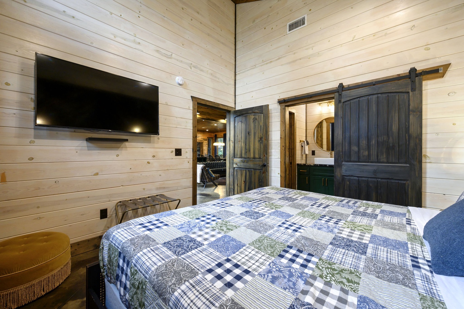 Your cozy retreat features rustic barn doors, warm wood-planked walls, and a crisp quilted bed—perfect for unwinding after a day of adventure.