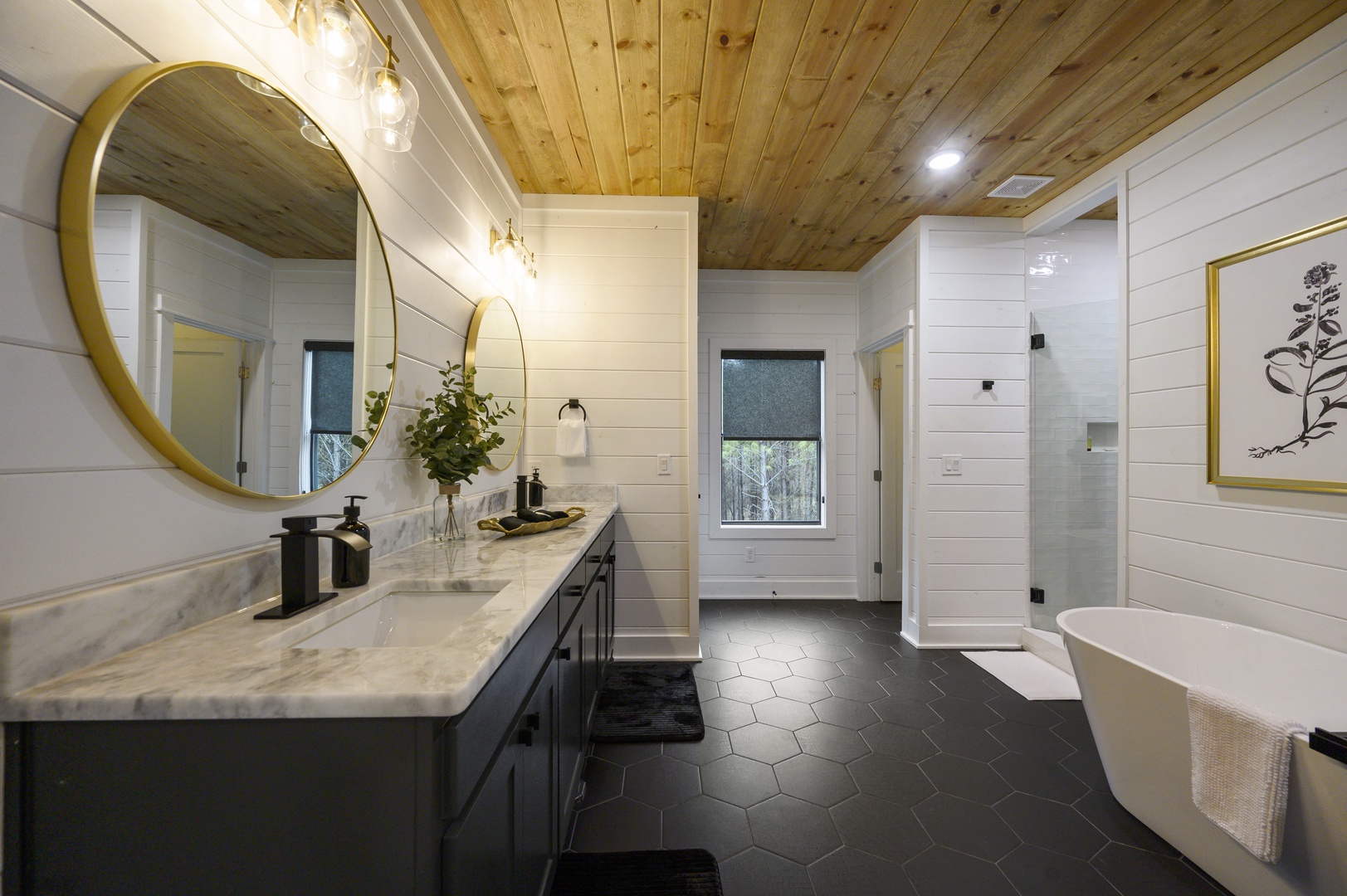 Indulge in your private spa-like retreat with marble counters, soaking tub, and rustic wood ceiling warmth.