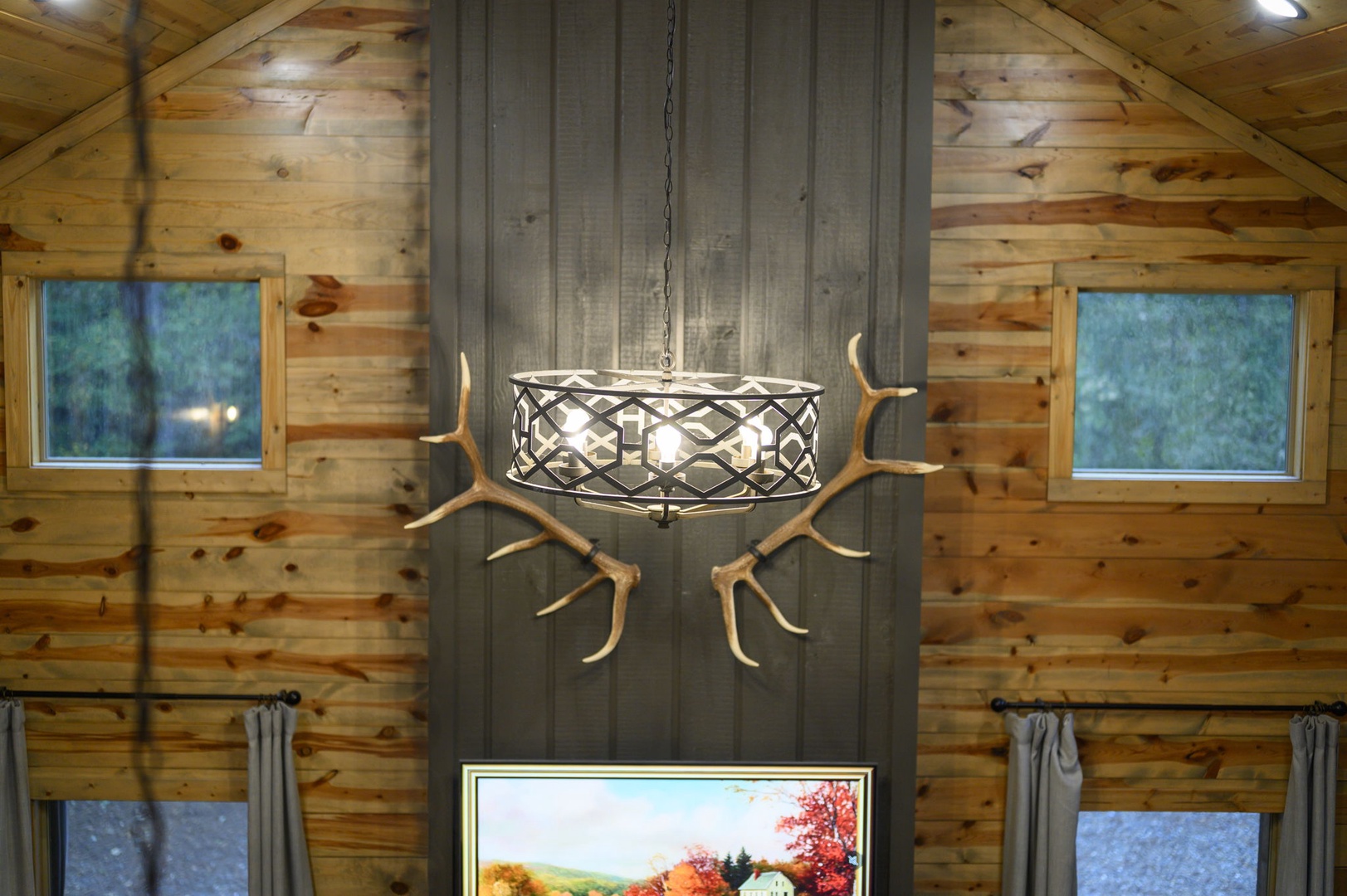 High ceilings and warm wood walls create your cozy mountain retreat, featuring rustic charm with natural touches and plenty of natural light streaming through the windows.